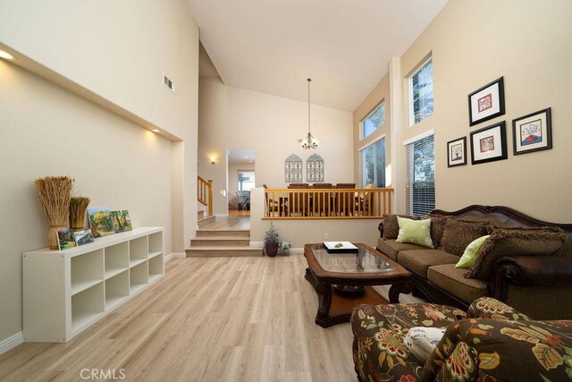 27829 Coldsprings Pl, Valencia, CA 91354 - living room with high vaulted ceiling, stairs, light wood finished floors, and a chandelier
