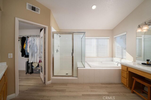 27829 Coldsprings Pl, Valencia, CA 91354 - bathroom with vanity, lofted ceiling, wood finished floors, a shower stall, and a garden tub