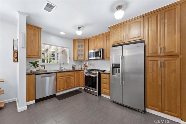 16728 Los Alimos St, Granada Hills, CA 91344 - kitchen featuring appliances with stainless steel finishes, glass insert cabinets, dark stone counters, dark tile patterned flooring, and recessed lighting