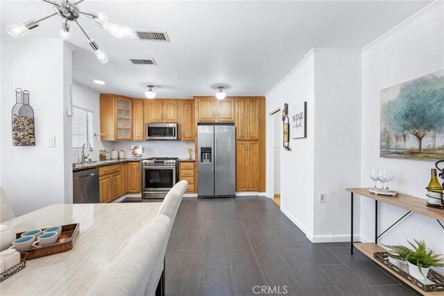 16728 Los Alimos St, Granada Hills, CA 91344 - kitchen featuring appliances with stainless steel finishes, glass insert cabinets, crown molding, brown cabinets, and stone counters