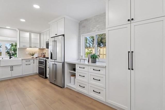 1358 Walnutview Dr, Encinitas, CA 92024 - kitchen featuring high end appliances, plenty of natural light, light wood finished floors, white cabinetry, and recessed lighting