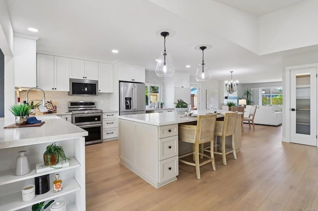 1358 Walnutview Dr, Encinitas, CA 92024 - kitchen with appliances with stainless steel finishes, recessed lighting, a kitchen island, light countertops, and light wood-type flooring