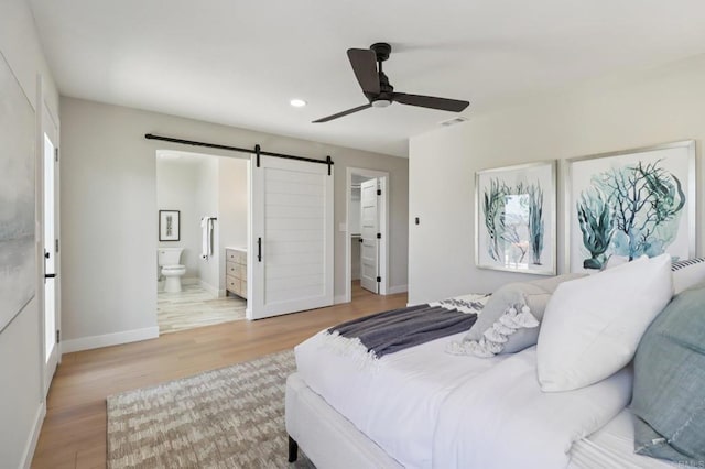 1358 Walnutview Dr, Encinitas, CA 92024 - bedroom with a barn door, light wood-style floors, a spacious closet, recessed lighting, and ensuite bath