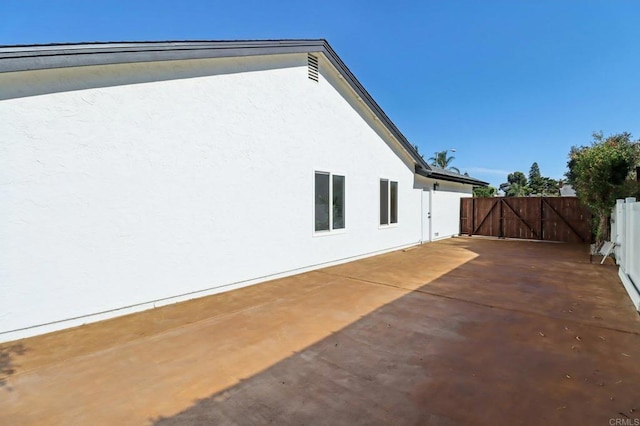 1358 Walnutview Dr, Encinitas, CA 92024 - view of side of property featuring stucco siding, a gate, and a patio