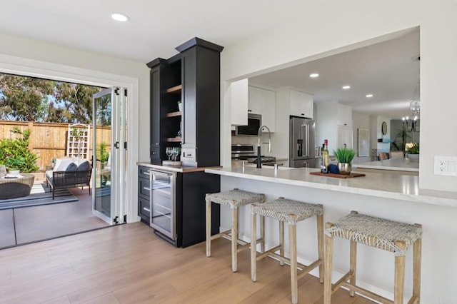 1358 Walnutview Dr, Encinitas, CA 92024 - kitchen featuring appliances with stainless steel finishes, wine cooler, a peninsula, light countertops, and recessed lighting