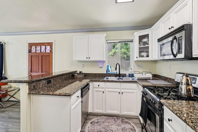8980 Lamar St # 6, Spring Valley, CA 91977 - kitchen featuring stainless steel appliances, a peninsula, light wood-style floors, and white cabinetry