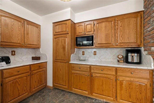 341 Mellane Cir, Orland, CA 95963 - kitchen with black microwave, brown cabinets, light countertops, and tasteful backsplash