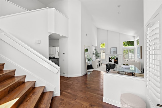 18 Saint Thomas, Laguna Niguel, CA 92677 - stairs with high vaulted ceiling, wood finished floors, and a lit fireplace