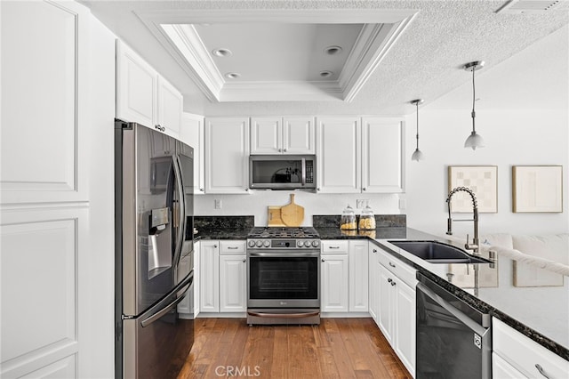 18 Saint Thomas, Laguna Niguel, CA 92677 - kitchen featuring stainless steel appliances, a raised ceiling, crown molding, dark wood-type flooring, and white cabinetry