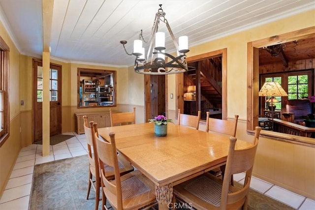 2310 Oak Haven Ln, Arroyo Grande, CA 93420 - dining space featuring light tile patterned floors, a chandelier, ornamental molding, wooden walls, and wood ceiling