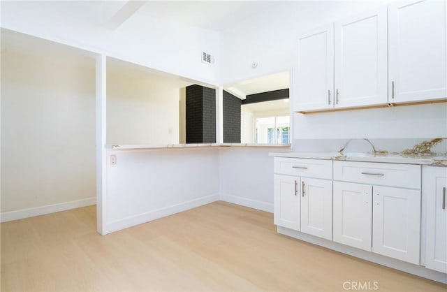 13870 Larwin Rd, La Mirada, CA 90638 - kitchen with light wood finished floors, white cabinetry, and light stone countertops