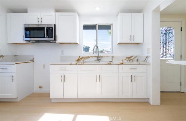 13870 Larwin Rd, La Mirada, CA 90638 - kitchen with stainless steel microwave, white cabinets, light wood-style flooring, light countertops, and recessed lighting