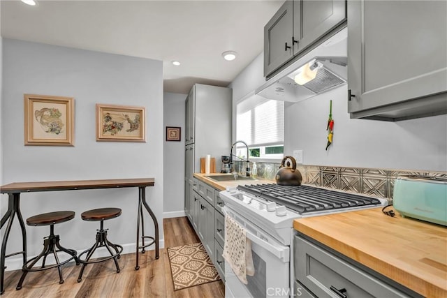 16635 Mountain View Dr, Cobb, CA 95426 - kitchen featuring white gas range oven, gray cabinets, butcher block countertops, under cabinet range hood, and recessed lighting