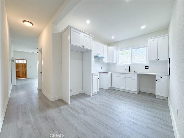 10408 Kalmia St, Los Angeles, CA 90002 - kitchen with under cabinet range hood, light wood finished floors, plenty of natural light, white cabinetry, and recessed lighting