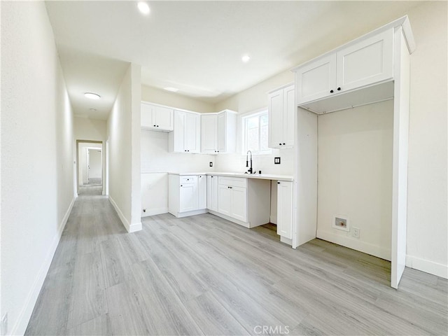 10408 Kalmia St, Los Angeles, CA 90002 - kitchen with light wood finished floors, white cabinetry, recessed lighting, and light countertops
