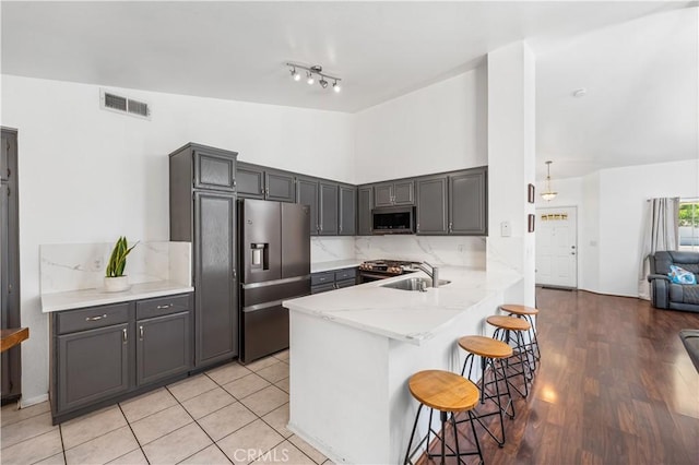 2019 Greentree St, Lancaster, CA 93535 - kitchen with stainless steel appliances, a breakfast bar area, a peninsula, light stone countertops, and open floor plan
