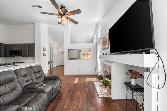 2019 Greentree St, Lancaster, CA 93535 - living room featuring ceiling fan, dark wood-style flooring, a fireplace with flush hearth, and high vaulted ceiling