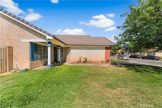 2019 Greentree St, Lancaster, CA 93535 - back of property featuring a yard, stucco siding, and a tiled roof