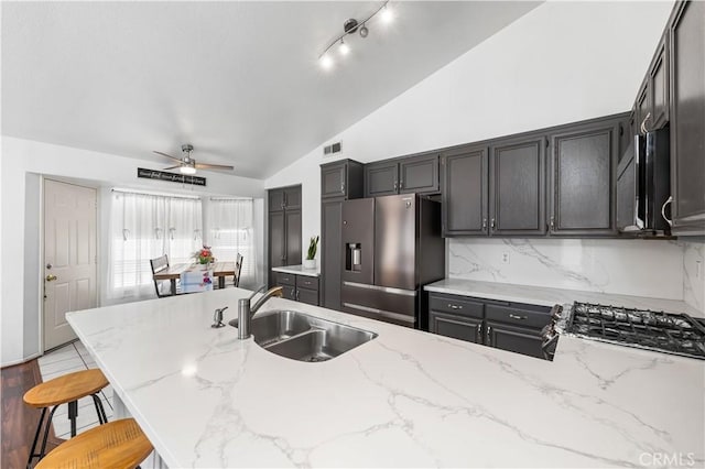 2019 Greentree St, Lancaster, CA 93535 - kitchen featuring appliances with stainless steel finishes, lofted ceiling, ceiling fan, light stone counters, and backsplash