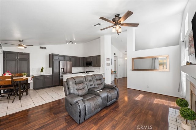 2019 Greentree St, Lancaster, CA 93535 - living area featuring ceiling fan, high vaulted ceiling, light wood-style floors, and a fireplace