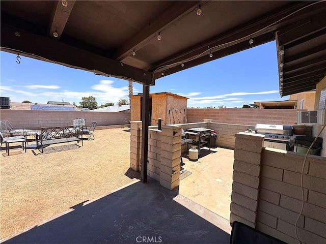 811 Mescal Dr, Barstow, CA 92311 - fenced backyard with a patio, a grill, and a storage shed