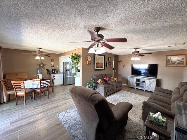 811 Mescal Dr, Barstow, CA 92311 - living room featuring light wood finished floors, a ceiling fan, and a textured ceiling