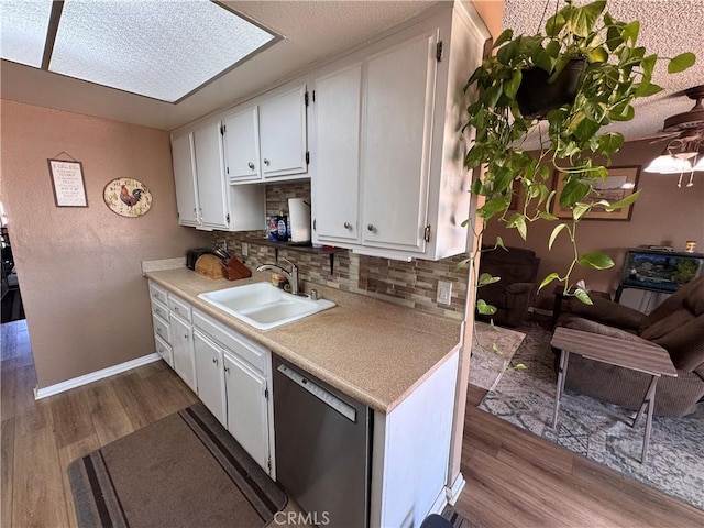 811 Mescal Dr, Barstow, CA 92311 - kitchen featuring dishwasher, decorative backsplash, dark wood finished floors, and white cabinetry