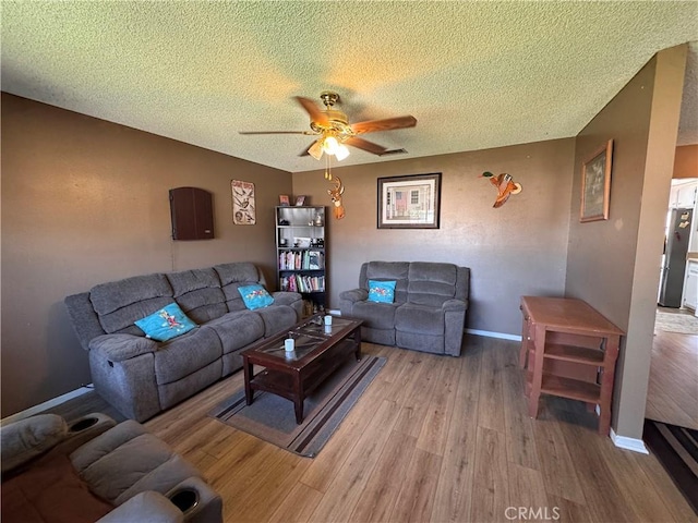 811 Mescal Dr, Barstow, CA 92311 - living room featuring a textured ceiling, light wood-type flooring, and ceiling fan