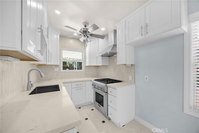 8328 Fernadel Ave, Pico Rivera, CA 90660 - kitchen featuring wall chimney exhaust hood, high end stainless steel range, ceiling fan, tasteful backsplash, and white cabinets