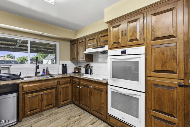 6100 Carter Ave, Bakersfield, CA 93308 - kitchen featuring white double oven, under cabinet range hood, backsplash, electric stovetop, and light stone counters