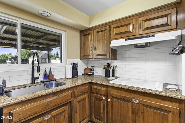6100 Carter Ave, Bakersfield, CA 93308 - kitchen featuring backsplash, under cabinet range hood, light stone counters, and white electric cooktop
