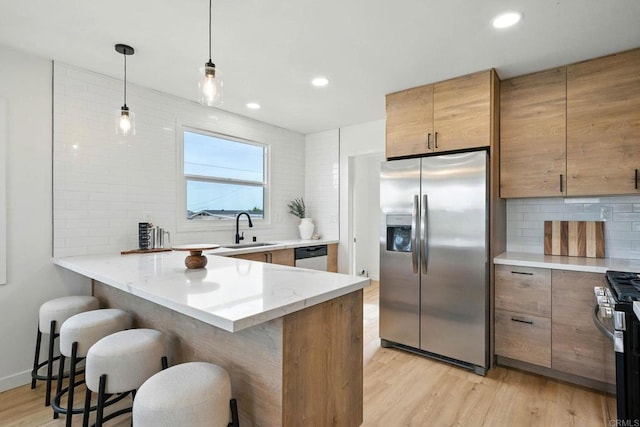 640 Pyramid St, San Diego, CA 92114 - kitchen featuring stainless steel appliances, tasteful backsplash, a kitchen bar, light wood-type flooring, and a peninsula