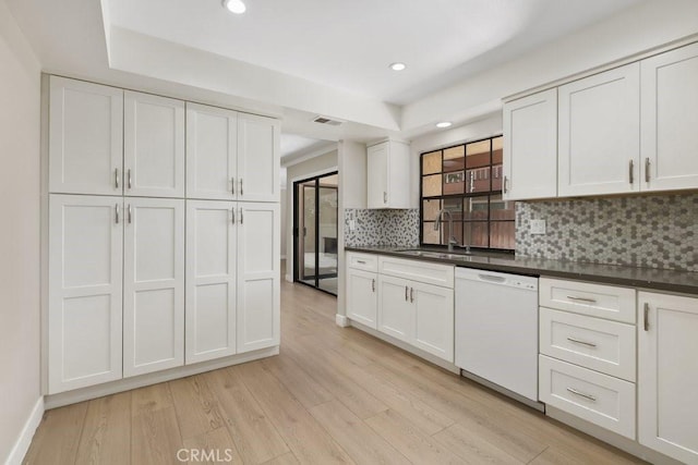 2639 Cameron Unit 119, Anaheim, CA 92801 - kitchen with white dishwasher, decorative backsplash, light wood-type flooring, dark countertops, and recessed lighting