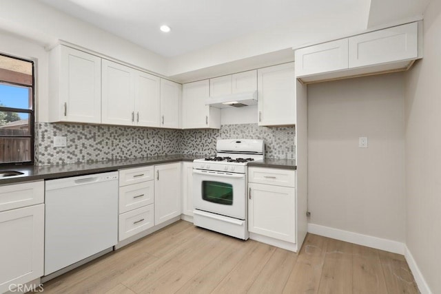 2639 Cameron Unit 119, Anaheim, CA 92801 - kitchen featuring white appliances, dark countertops, light wood finished floors, custom exhaust hood, and white cabinets
