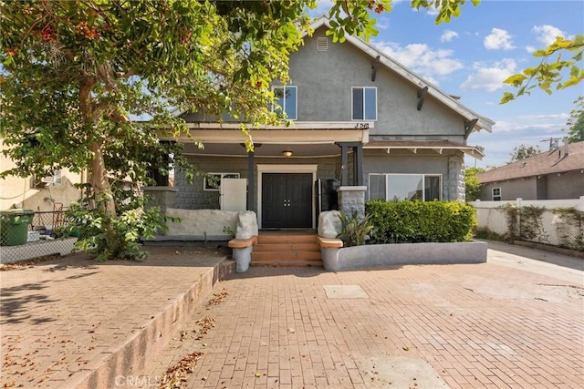 3561 E 6th St, Los Angeles, CA 90023 - view of front of home featuring stucco siding, stone siding, and covered porch