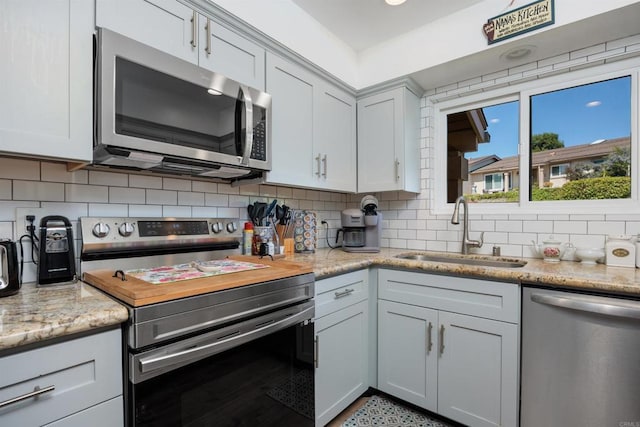 4396 Albatross Way, Oceanside, CA 92057 - kitchen with appliances with stainless steel finishes, decorative backsplash, and light stone counters