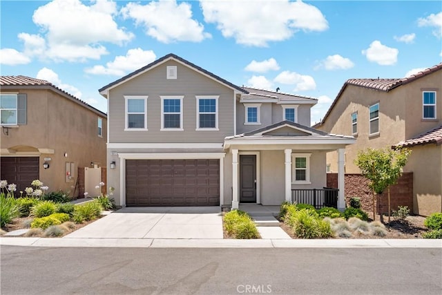16017 Tanzinite Ln, Chino, CA 91708 - traditional-style house with a porch, concrete driveway, a garage, and stucco siding