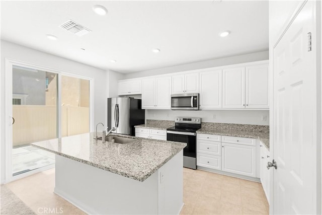 16017 Tanzinite Ln, Chino, CA 91708 - kitchen with stainless steel appliances, white cabinetry, an island with sink, light stone counters, and recessed lighting