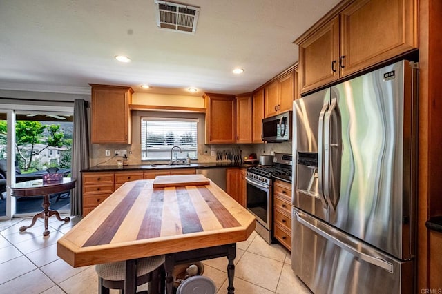 1926 Pamela Ln, Escondido, CA 92026 - kitchen featuring appliances with stainless steel finishes, light tile patterned flooring, healthy amount of natural light, recessed lighting, and crown molding