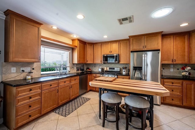 1926 Pamela Ln, Escondido, CA 92026 - kitchen with appliances with stainless steel finishes, brown cabinets, tasteful backsplash, dark countertops, and recessed lighting
