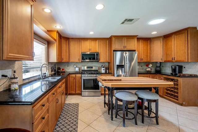 1926 Pamela Ln, Escondido, CA 92026 - kitchen with stainless steel appliances, brown cabinetry, tasteful backsplash, light tile patterned flooring, and recessed lighting