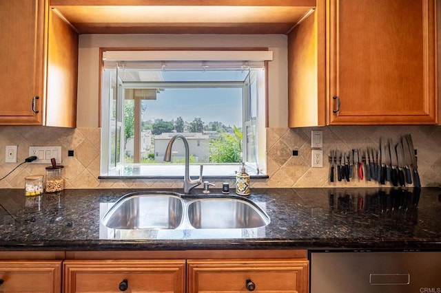 1926 Pamela Ln, Escondido, CA 92026 - kitchen with stainless steel dishwasher, brown cabinetry, dark stone counters, and backsplash