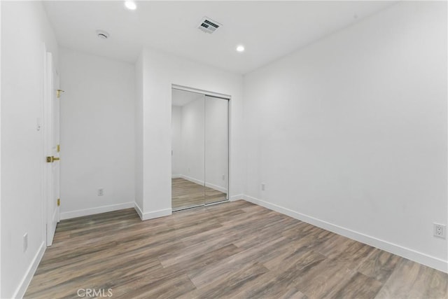 5171 S Wilton Pl, Los Angeles, CA 90062 - unfurnished bedroom with a closet, wood finished floors, and recessed lighting