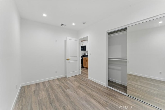 5171 S Wilton Pl, Los Angeles, CA 90062 - unfurnished bedroom with light wood-style floors, recessed lighting, and a closet