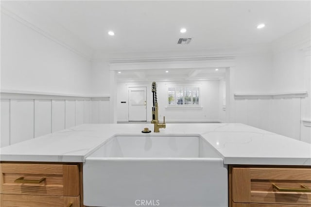 5171 S Wilton Pl, Los Angeles, CA 90062 - kitchen with a decorative wall, brown cabinets, light stone countertops, a wainscoted wall, and recessed lighting