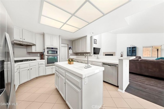 4018 Via Barbara, Lancaster, CA 93536 - kitchen with stainless steel appliances, open floor plan, light tile patterned floors, under cabinet range hood, and a center island