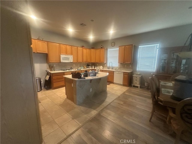 1185 Lantana Rd, Beaumont, CA 92223 - kitchen with white appliances, a center island, light countertops, light brown cabinets, and light tile patterned floors