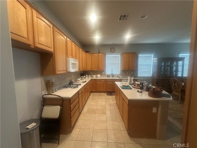 1185 Lantana Rd, Beaumont, CA 92223 - kitchen featuring white appliances, light countertops, a center island, light tile patterned floors, and light brown cabinets