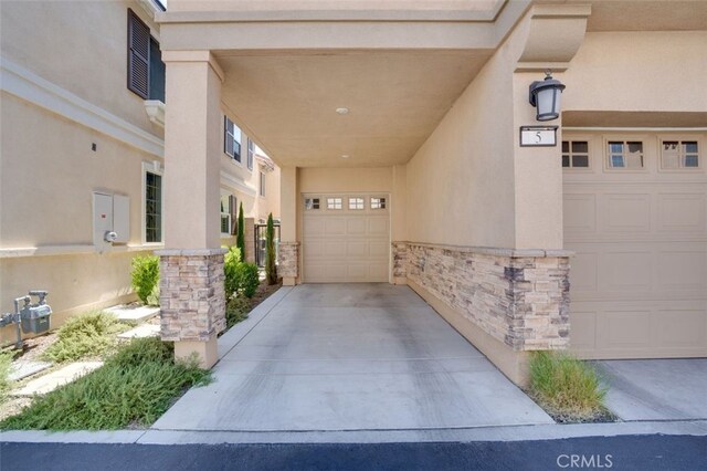 15147 Ridge Ln Unit 5, Fontana, CA 92336 - doorway to property featuring stone siding, stucco siding, and concrete driveway