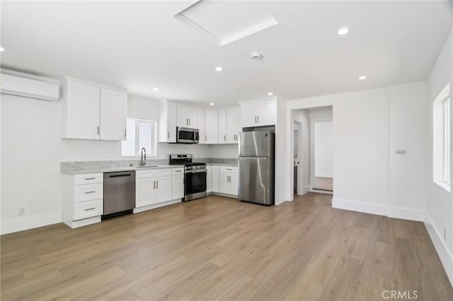 17043 Celtic St, Granada Hills, CA 91344 - kitchen featuring stainless steel appliances, a wall mounted AC, white cabinets, recessed lighting, and light wood-style floors